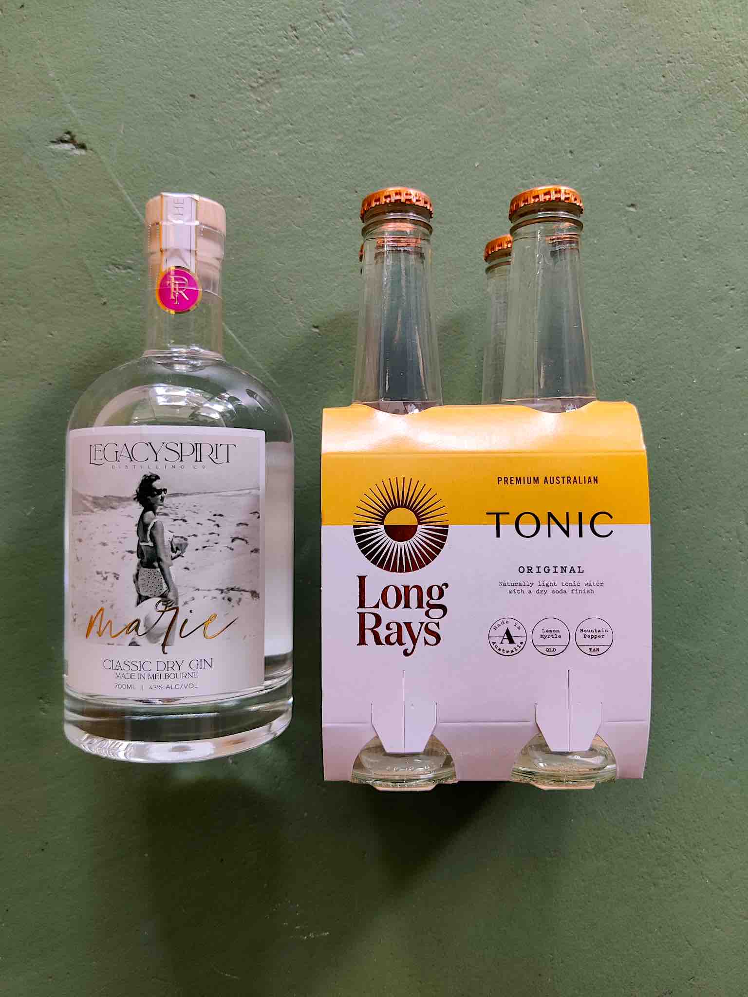 A bottle of Legacy Spirit Marie gin with a 4 pack of Long Rays Original Tonic